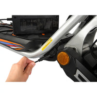 Charging the KuKirin A1 scooter: hand plugging the charger into the charging port, showing battery charging setup