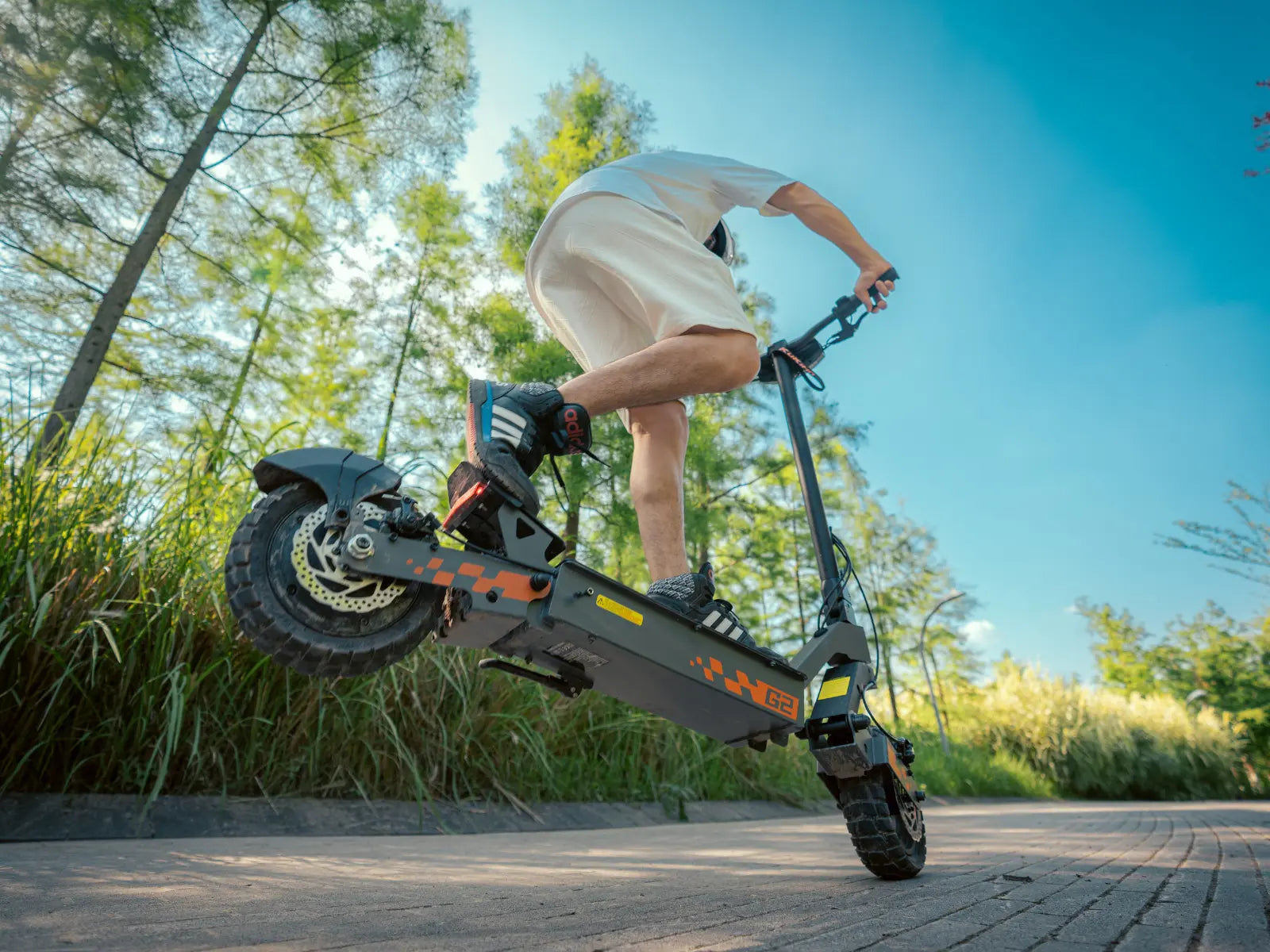 2026 Kukirin G2 electric scooter action shot, showing the scooter being ridden outdoors