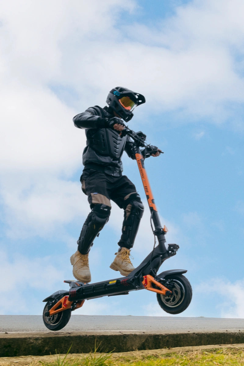 KuKirin G3 Pro electric scooter with dual 1200W motors, the most powerful model in KuKirin lineup, rider jumping curb for off-road performance demo, max speed 65km/h, 35° climbing capability, comparable to premium high-end scooters with excellent cost performance